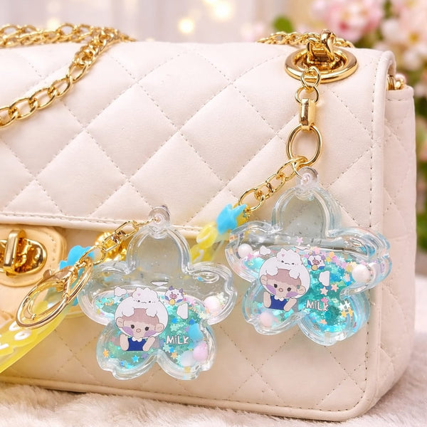 Decorative keychains with cartoon characters on a white quilted handbag.